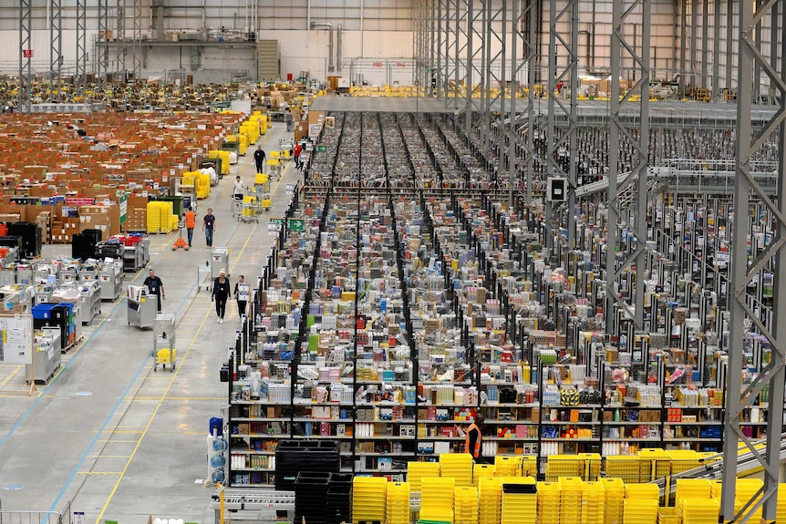 Many shelves line the floor of a huge warehouse.