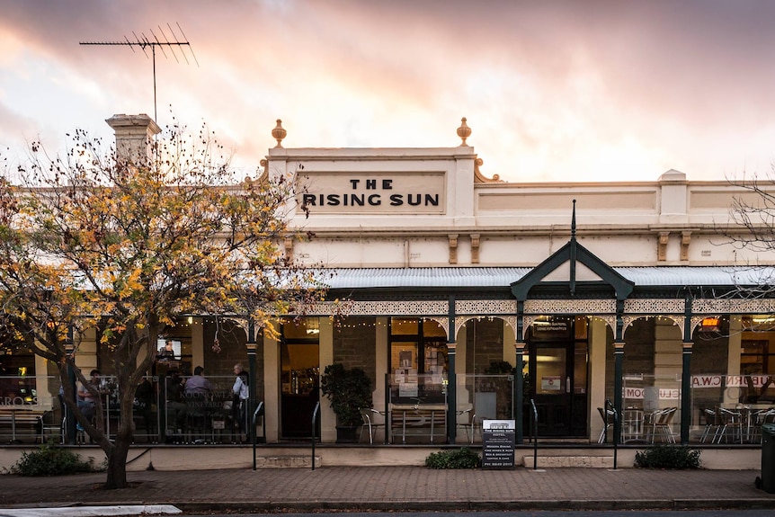 The Rising Sun Hotel- a heritage building with a sunset in the background.