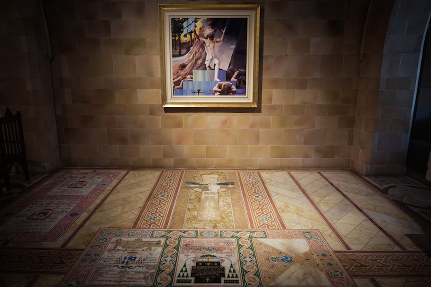 Colourful tiles form artwork on the ground as a painting hangs above it on a sandstone wall