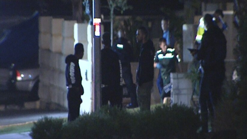 People in front of the house where three men were shot in Banksia Grove.