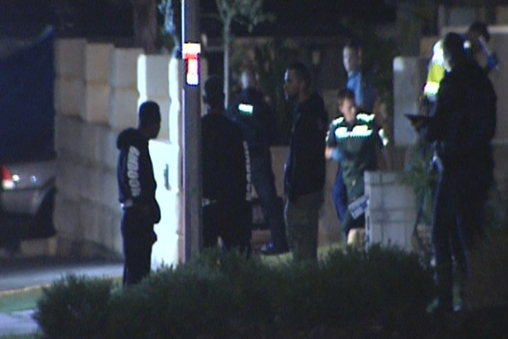 People in front of the house where three men were shot in Banksia Grove.