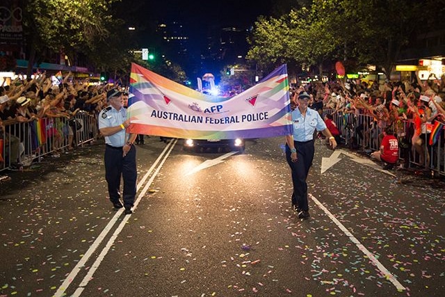 Two officers hold a banner saying Australian Federal Police in the Mardi Gras parade