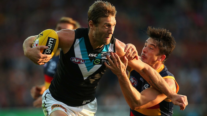 Port Adelaide's Jay Schulz is tackled by Adelaide's Matthew Jaensch at Adelaide Oval.