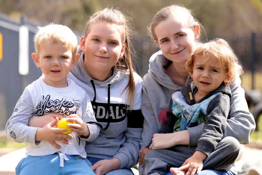 Two mothers sit with their young sons