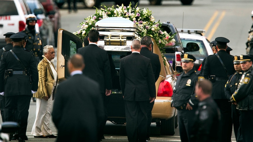 Pall-bearers load the casket of pop singer Whitney Houston into a hearse