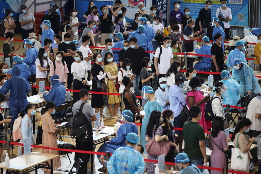 Masked crowds line up to get tested for COVID during Nanjing's first round of mass testing.
