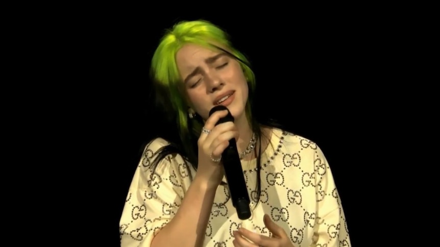 Screenshot of Billie Eilish singing; dressed in Gucci