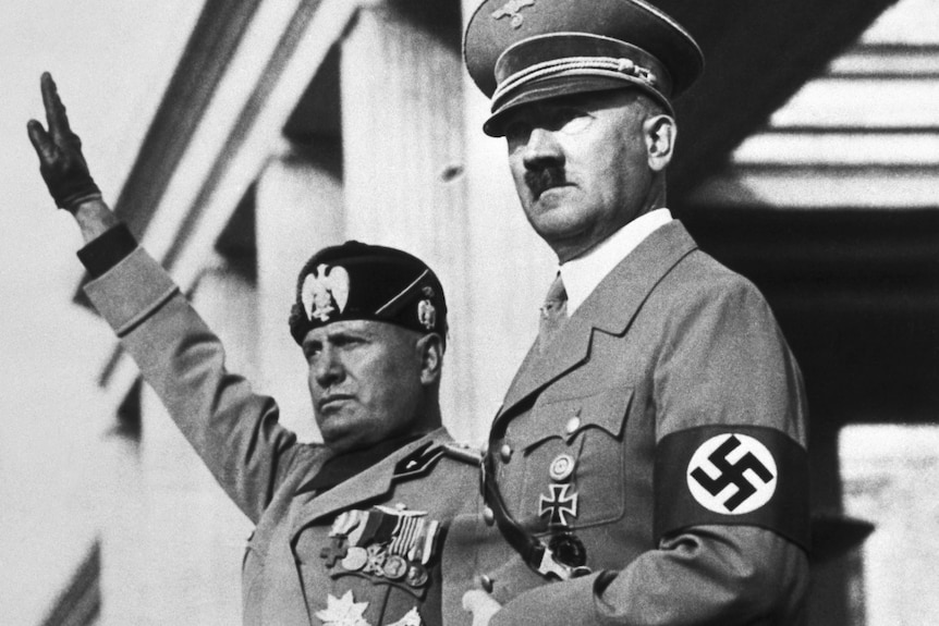 A black and white photo of Benito Mussolini giving a fascist salute next to Adolf Hitler