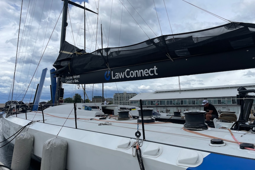 A yacht named LawConnect sits beside a wharf.