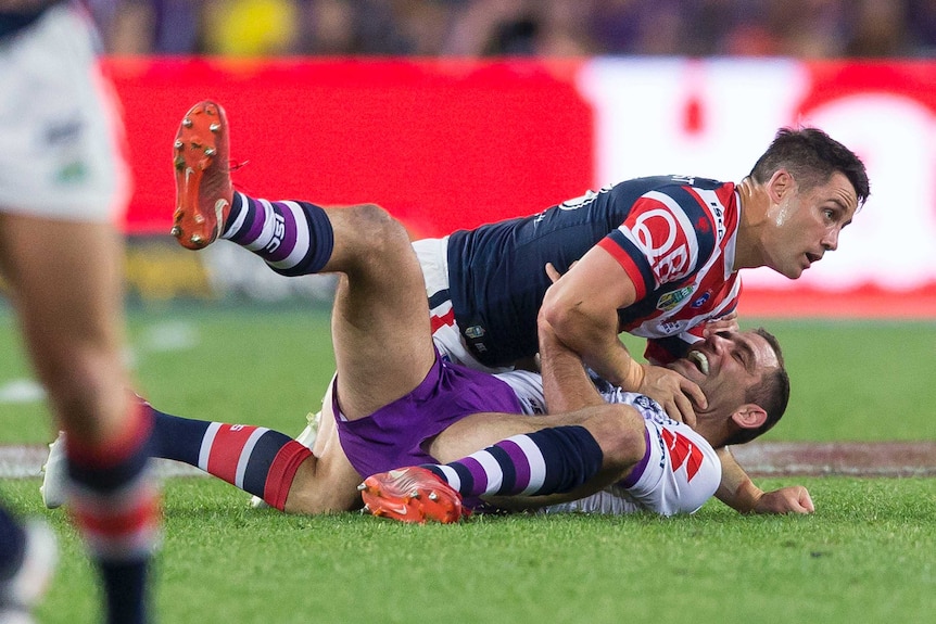 Cameron Smith and Cooper Cronk on the ground during the NRL grand final.