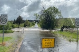 Road flooded with a warning sign.
