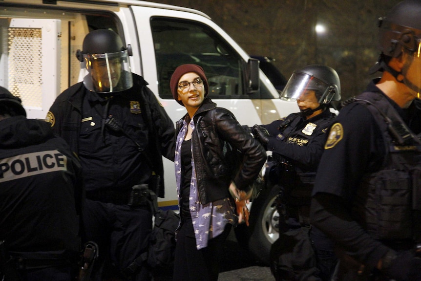 Police detain a demonstrator during a protest against the election.