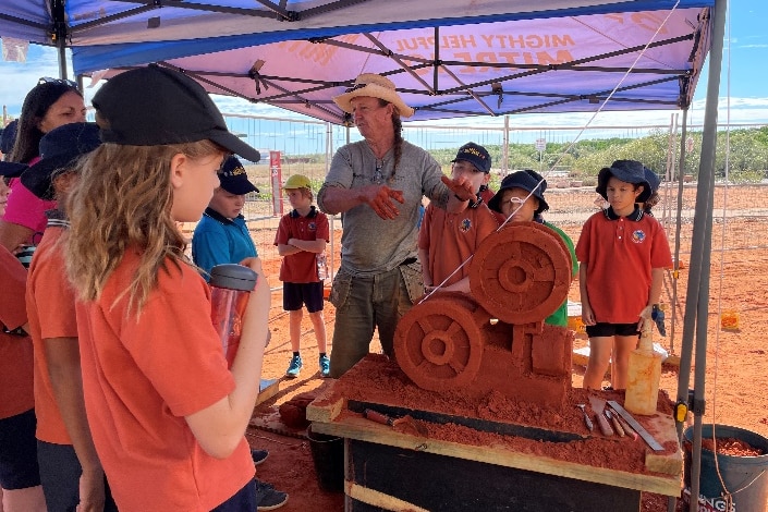 Tim Darby teaching a group of eager kids about sand sculpting 