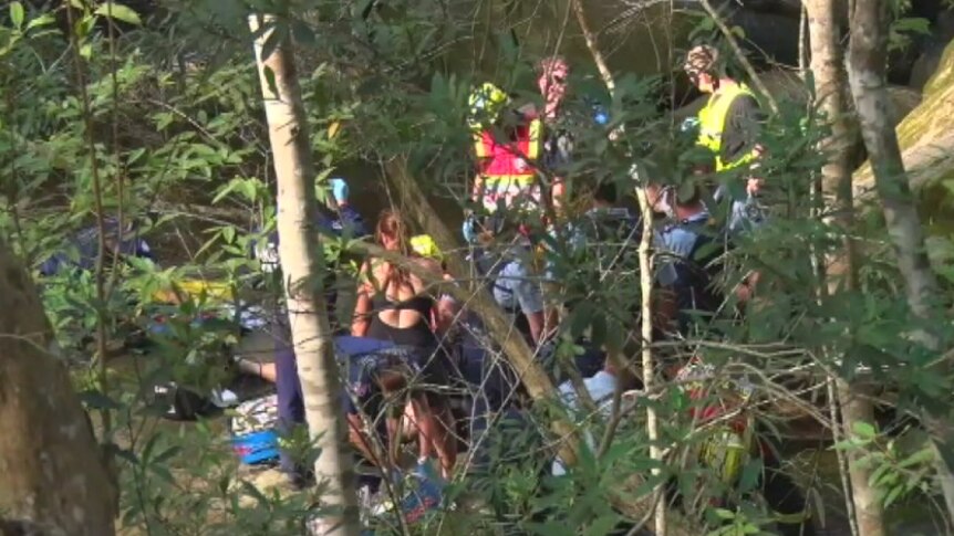 Emergency workers recover the body of a man who died when he fell off a cliff in Somersby Falls, near Gosford.