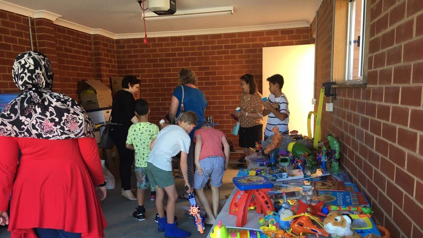 Anak-anak sedang mengerubuti meja yang penuh dengan mainan