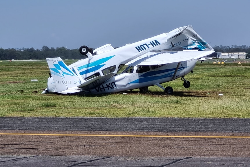 A light plane lays upside-down on top of another light aircraft