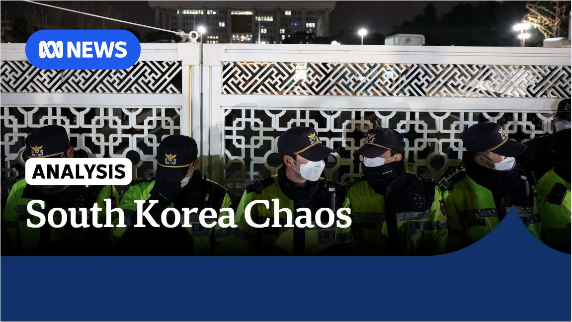 South Korea Chaos: Policemen from national guard crouch down next to fence