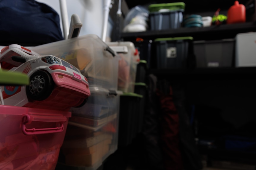 Containers of belongings stacked in a garage.