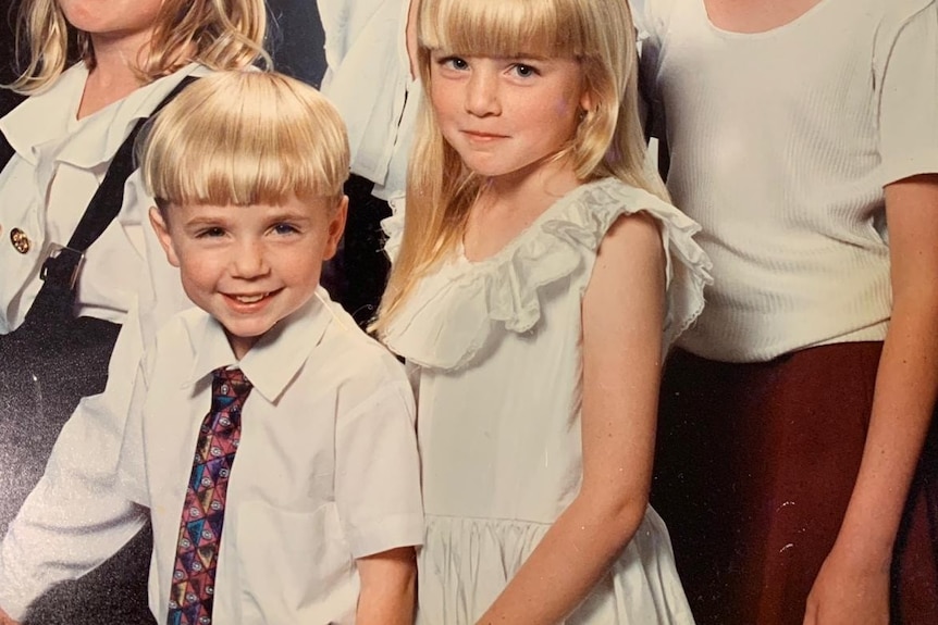 Young blonde haired boy, in white shirt with tie.
