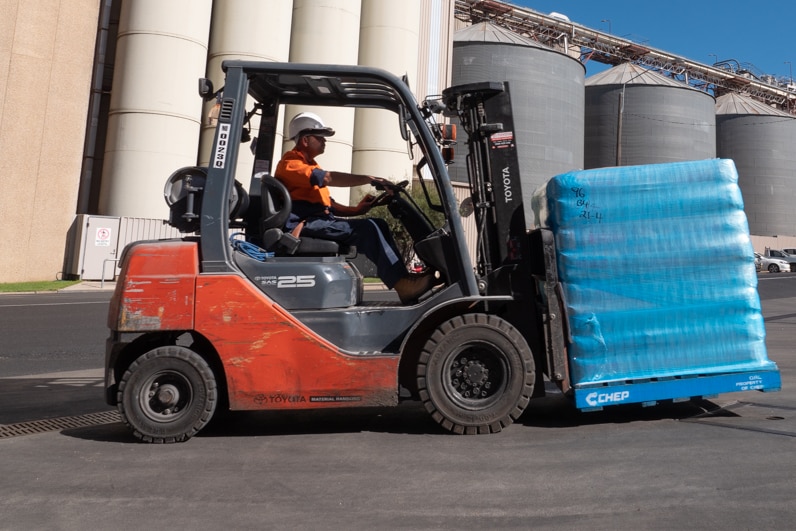 A forklift carrying bags of flour