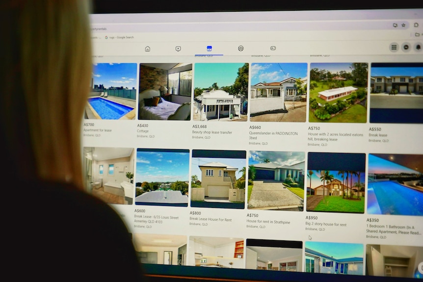 An unidentified person looks at a screen with property for rent on it.