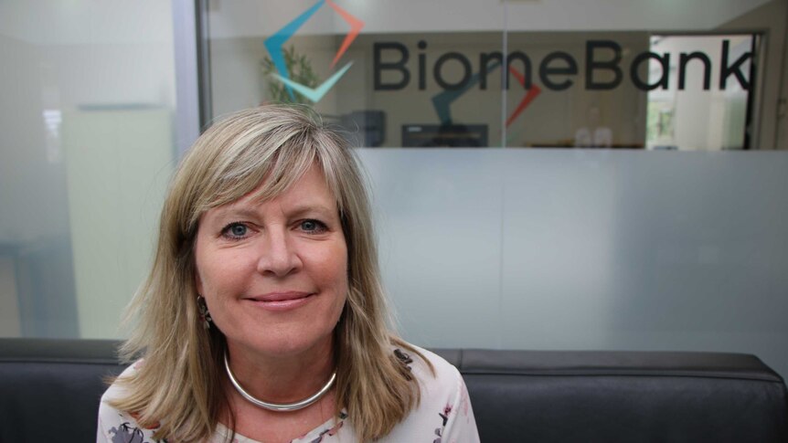A close-up photo of a lady with the BiomeBank logo in the background.