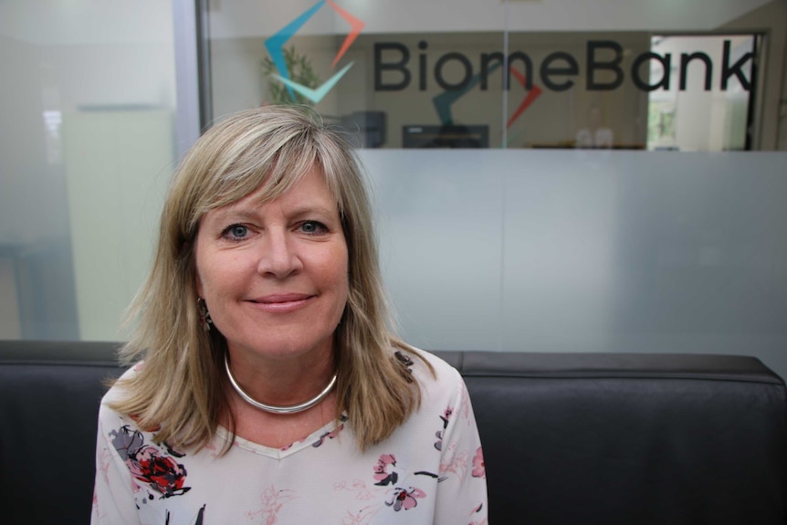 A close-up photo of a lady with the BiomeBank logo in the background.