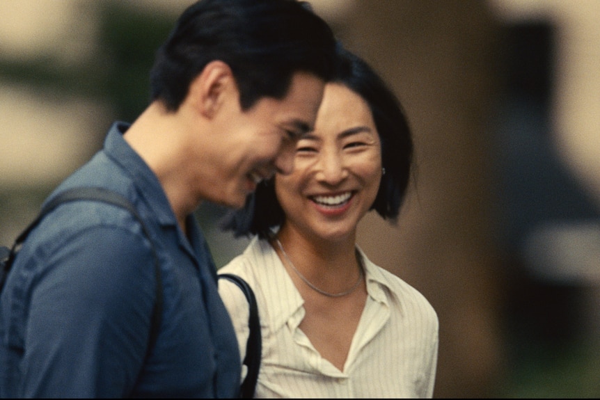 Actors Greta Lee and Teo Yoo laugh in the film Past Lives.