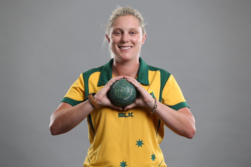 Natasha Van Eldik holds a bowl in front of her chest and smiles.