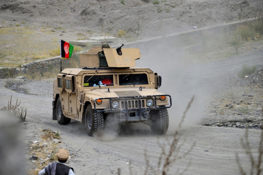Afghan security forces patrol on a Humvee vehicle