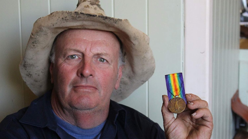 Western Queensland grazier Andrew Martin with a World War I medal found on his remote sheep property  'Toolmaree' at Tambo