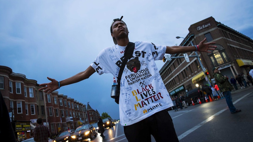 Baltimore demonstrator stands with outstretched hands