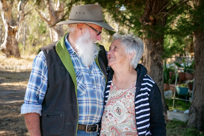 An older couple gaze lovingly into each other's eyes.