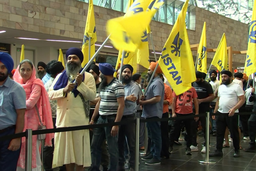 A queue of people holding pro-Khalistan flags