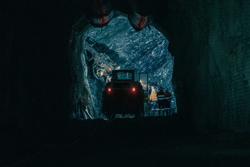 A truck is silhouetted in an underground mine.