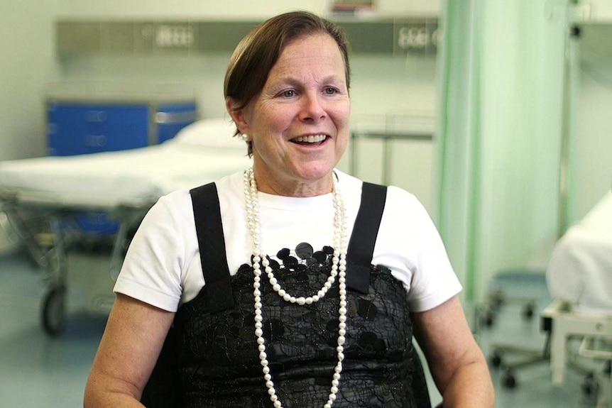 Fiona Wood wears a white shirt, black dress and a pearl necklace