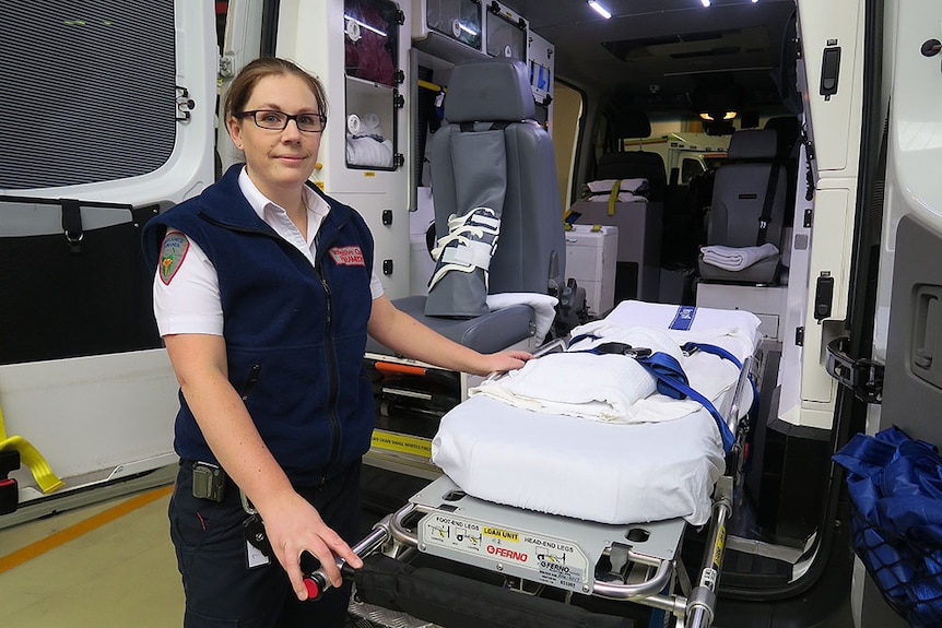 Lauren Hepher next to rear of ambulance, with doors open.