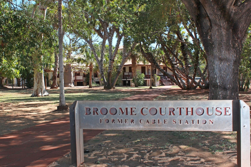Exterior shot of a building surrounded by trees and a sign that reads 'Broome Courthouse : former cable station'.