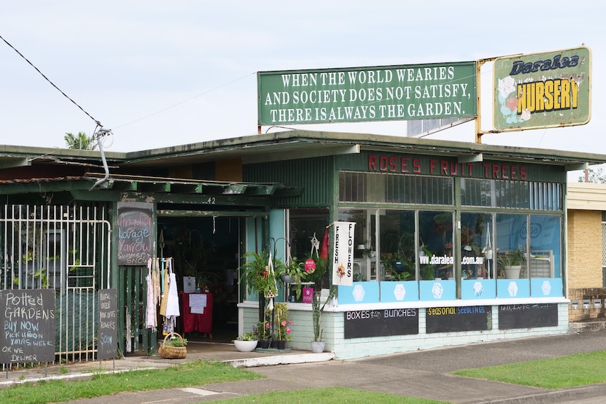 The front of a garden nursery shop, with a weathered sign and quote including the words 'there's always the garden'.