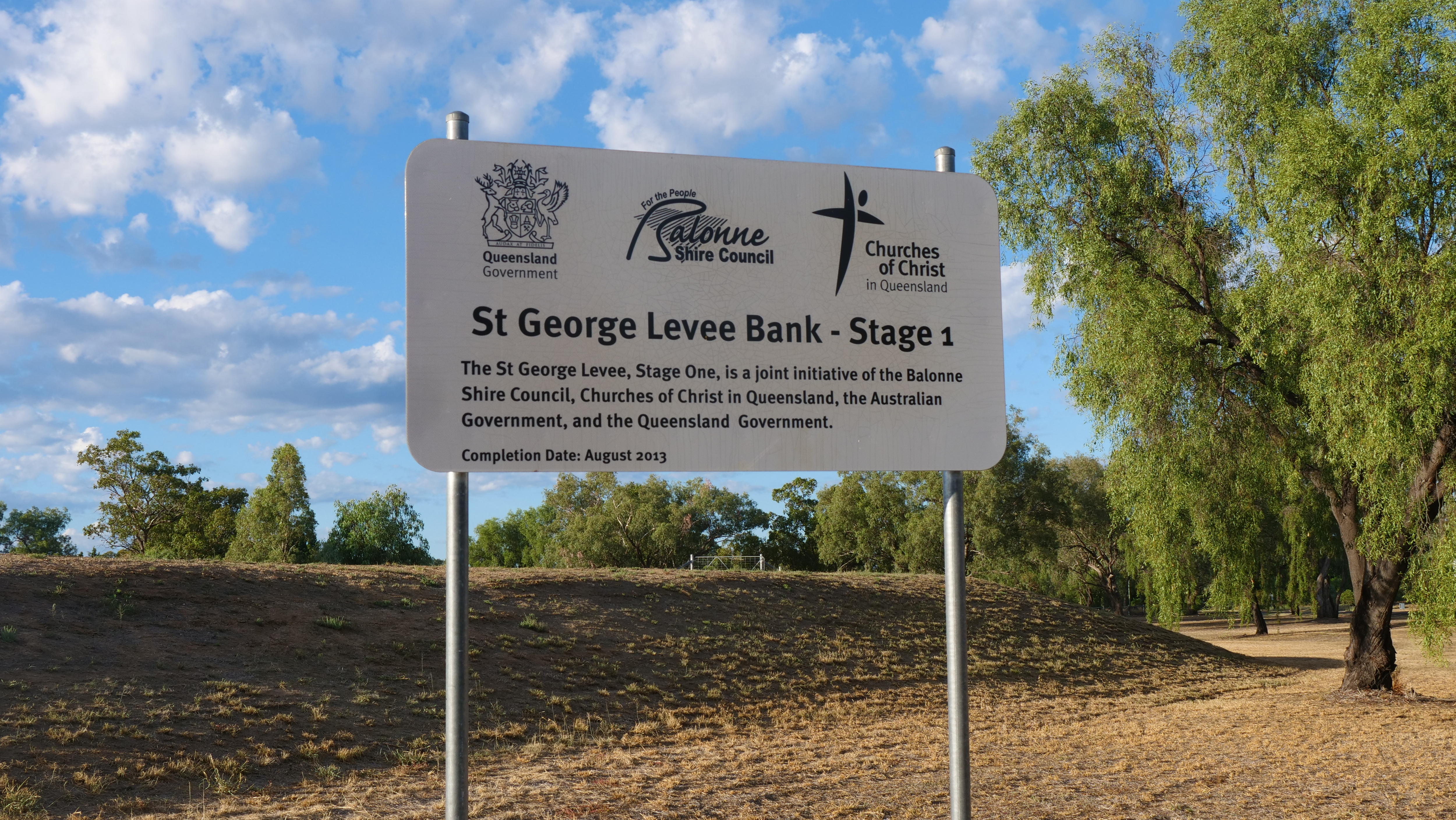 Un cartel que decía St. George Levee Bank frente a un montículo de tierra