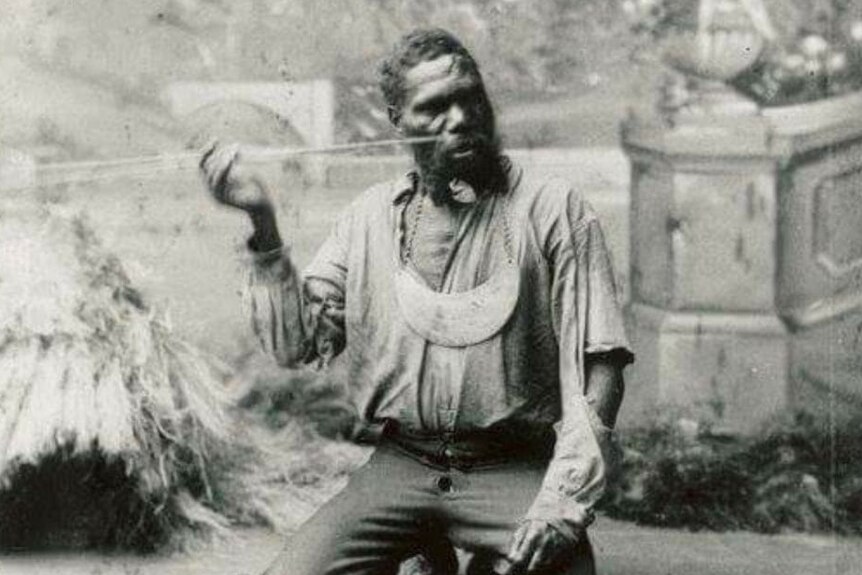 Black and white historic photo of Yuggera man King Billy Turner kneeling on the ground, circa 1800s.