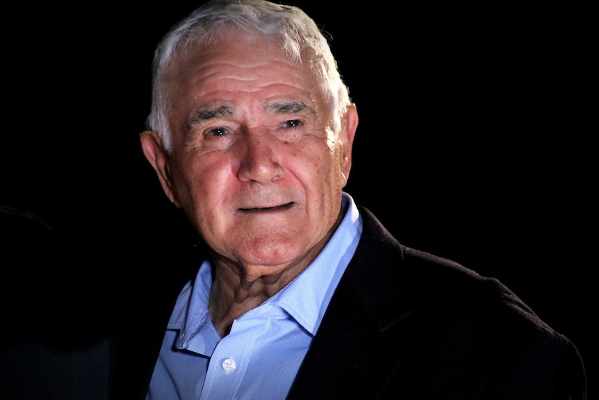 A smiling Tito Teraci poses for a photo against a black background.