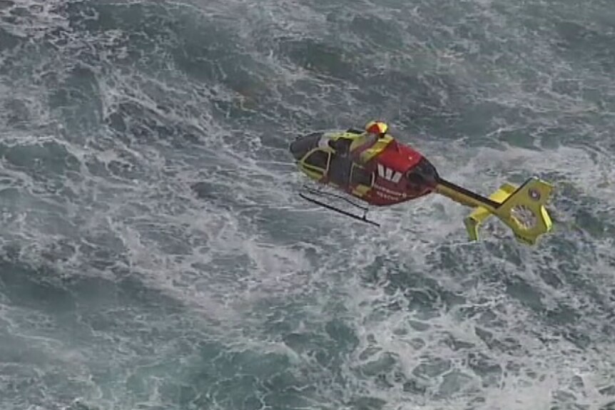 A Surf Life Saving Queensland helicopter searches around Main Beach