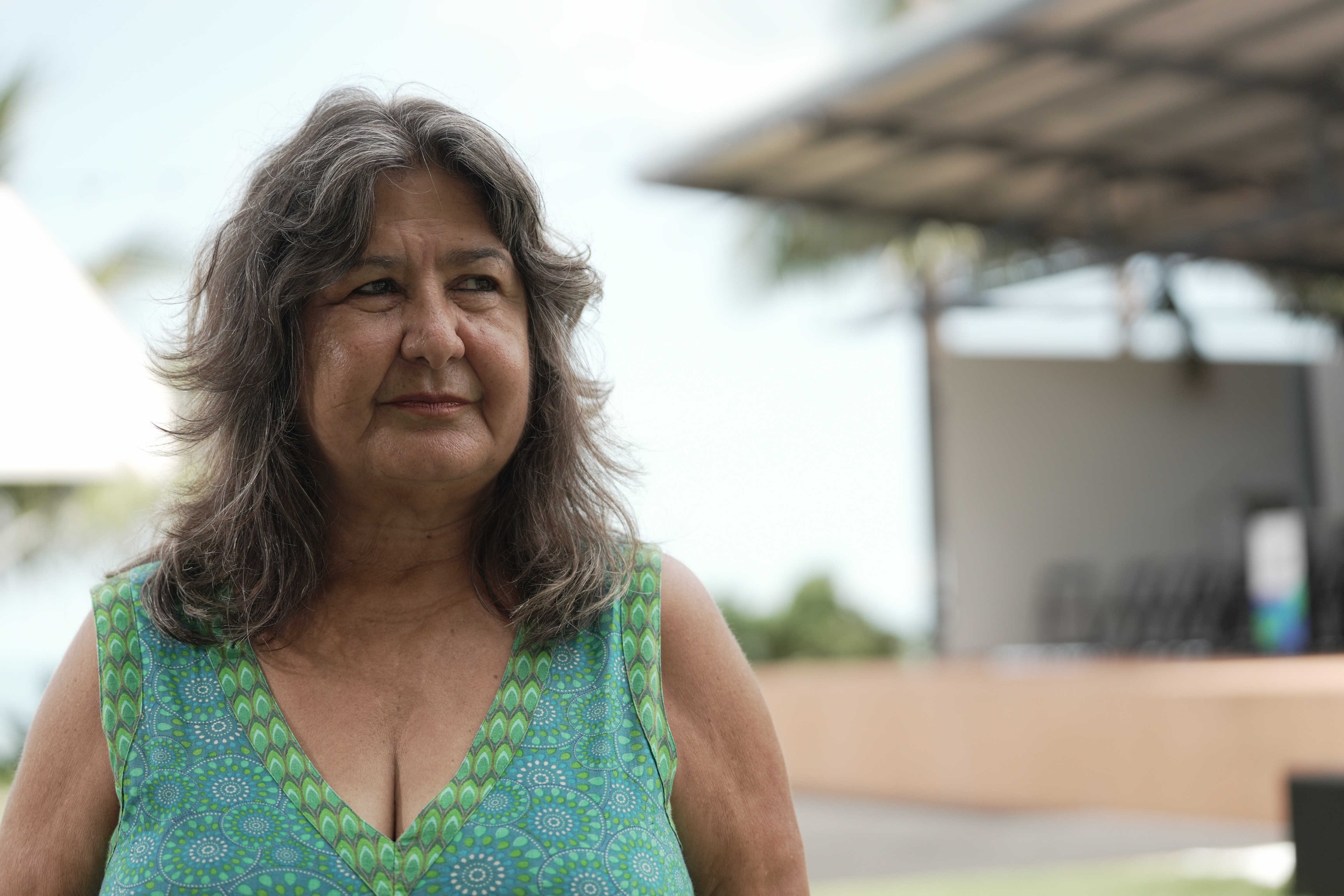 Portrait of a woman with grey hair and a green dress.