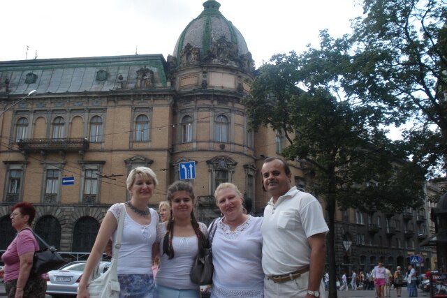 A group of people standing in front of a historic-looking building.
