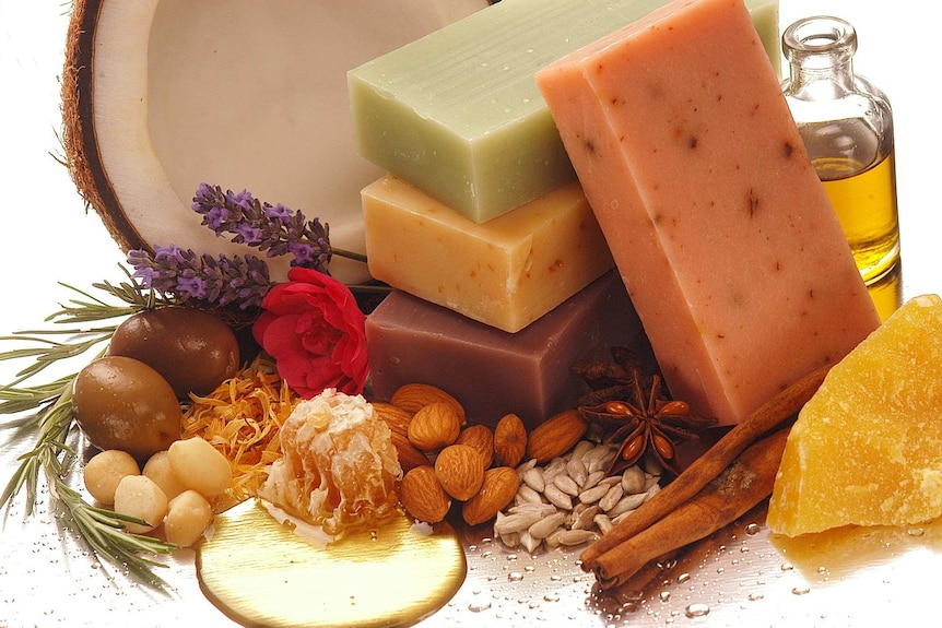 Soap bars surrounded by herbs and food products