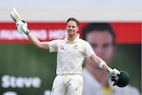 Steve Smith raises his bat after scoring a century in the first Ashes Test at the Gabba.
