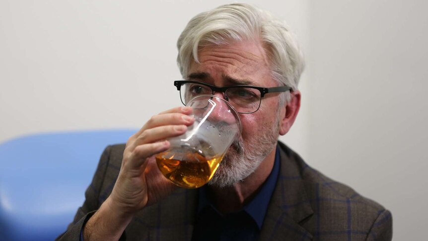 Shaun Micallef with a beaker of beer for documentary On The Sauce about Australia's relationship with alcohol