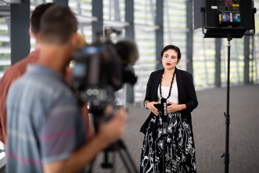 NT Education Minister Lauren Moss speaking in front of cameras at a press conference. 