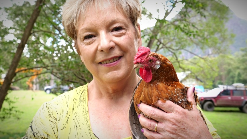 A woman holds a chicken